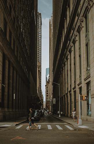 urban woman walking on street between building during daytime building